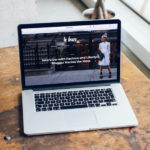 Mac ouvert sur un bureau avec un blog WordPress en fond d'écran