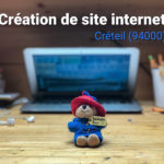 Ordinateur portable fermé sur un bureau avec textes création de site internet à Créteil